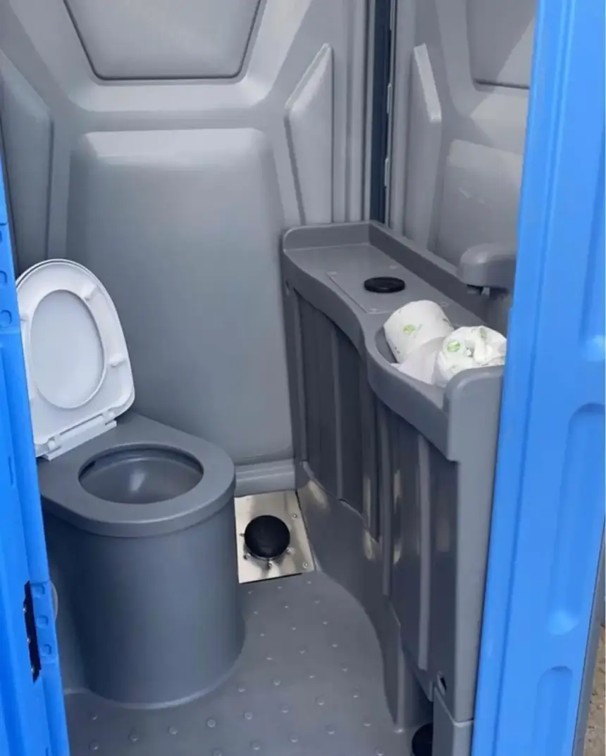Porta potty interior with sanitizer dispenser and toilet