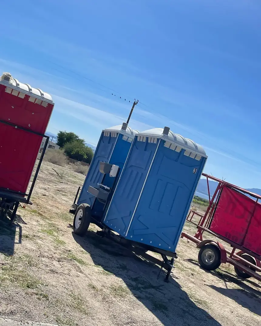 Towable porta potty trailer parked at a work site